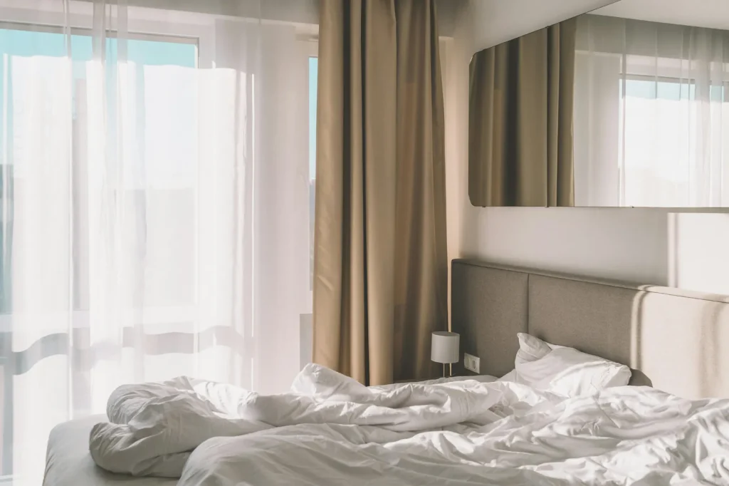 Quiet bedroom with soft morning light, the kind of room acoustic secondary glazing helps